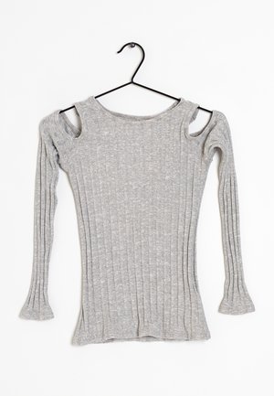 Pull en maille côtelée grise avec manches longues et découpes aux épaules, suspendu sur un cintre noir sur fond blanc.