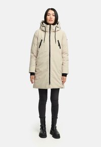 Beige waterdichte parka met capuchon, ritssluiting aan de voorkant en twee met rits afsluitbare zakken. Voorzien van zwarte accenten en een ontspannen pasvorm.