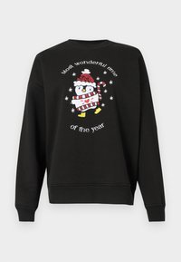 Melns sporta krekls ar apaļu kaklu, ar izšūtu pingvīnu, kas valkā sarkanu un baltu svītrainu šalli un cepuri, kā arī uzrakstu "Visbrīnišķīgākais laiks gadā".