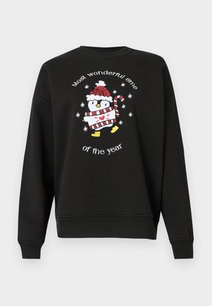 Fekete pulóver kerek nyakkal, hímzett pingvinnel, aki piros és fehér csíkos sálat és sapkát visel, valamint a "Legcsodálatosabb időszak az évben" felirattal.