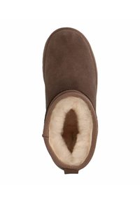 Bottine en suède marron avec un intérieur doublé de crème douce. Bout arrondi, design minimaliste et détails de couture sur le bord. Semelle plate.