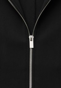 Black zip-up jacket with a silver metal zipper, featuring smooth fabric texture and clean edges along the zip closure.