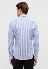 Blauw-witte gestreepte blouse met lange mouwen, met een uitslaande kraag, een getailleerde pasvorm, knopenmanchetten en een gebogen onderrand. Glad, licht textuur van de stof.