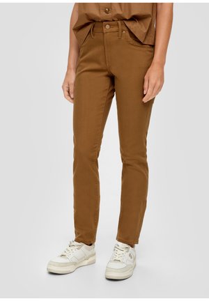 Braune, taillierte Jeanshose aus Denim mit einem klassischen Five-Pocket-Design, vorn mit Knopfverschluss und kombiniert mit weißen Sneakers.