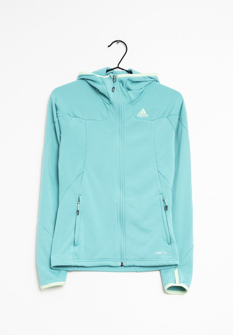 Veste Adidas bleu clair zippée avec capuche, deux poches zippées et trous pour les pouces aux manches, présentée sur un cintre noir.