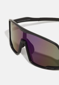 Schwarze sportliche Sonnenbrille mit übergroßen, verlaufenden lila Gläsern und einem Wraparound-Design. Die Materialien sind leichtes Plastik mit stabilen Rahmen.