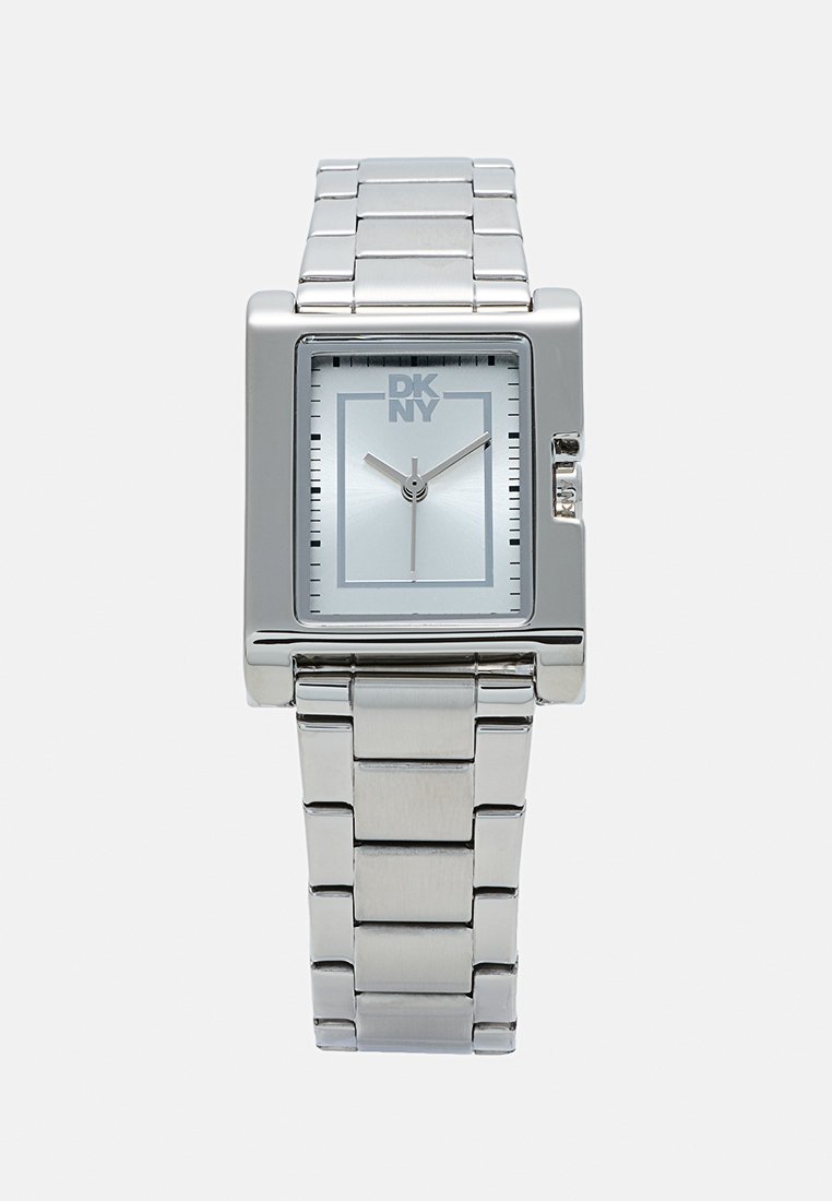 Montre DKNY rectangulaire en argent avec un cadran bleu clair, bracelet en maillons métalliques, index horaires minimalistes et logo imprimé sur le cadran.