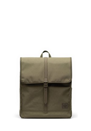 Sac à dos kaki de forme carrée avec motif en losange, fermeture à boucle à l’avant, poignée supérieure et petite étiquette logo en bas à droite.