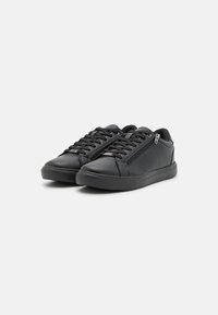 Schwarze synthetische Sneaker mit glatter Oberfläche, ausgestattet mit einem strukturierten Seitenpaneel, Schnürsenkeln und einem seitlichen Reißverschluss für einen einfachen Zugang. Gummisohle.