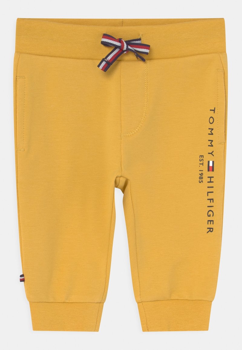 Pantalon de jogging jaune pour tout-petit avec poignets côtelés, nœud coulissant à rayures, poches latérales et logo vertical Tommy Hilfiger sur la jambe.