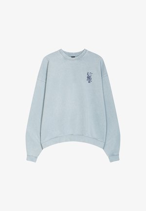 Light blue sweatshirt with a relaxed fit, featuring a crew neck, dropped shoulders, and a navy graphic design on the left chest.