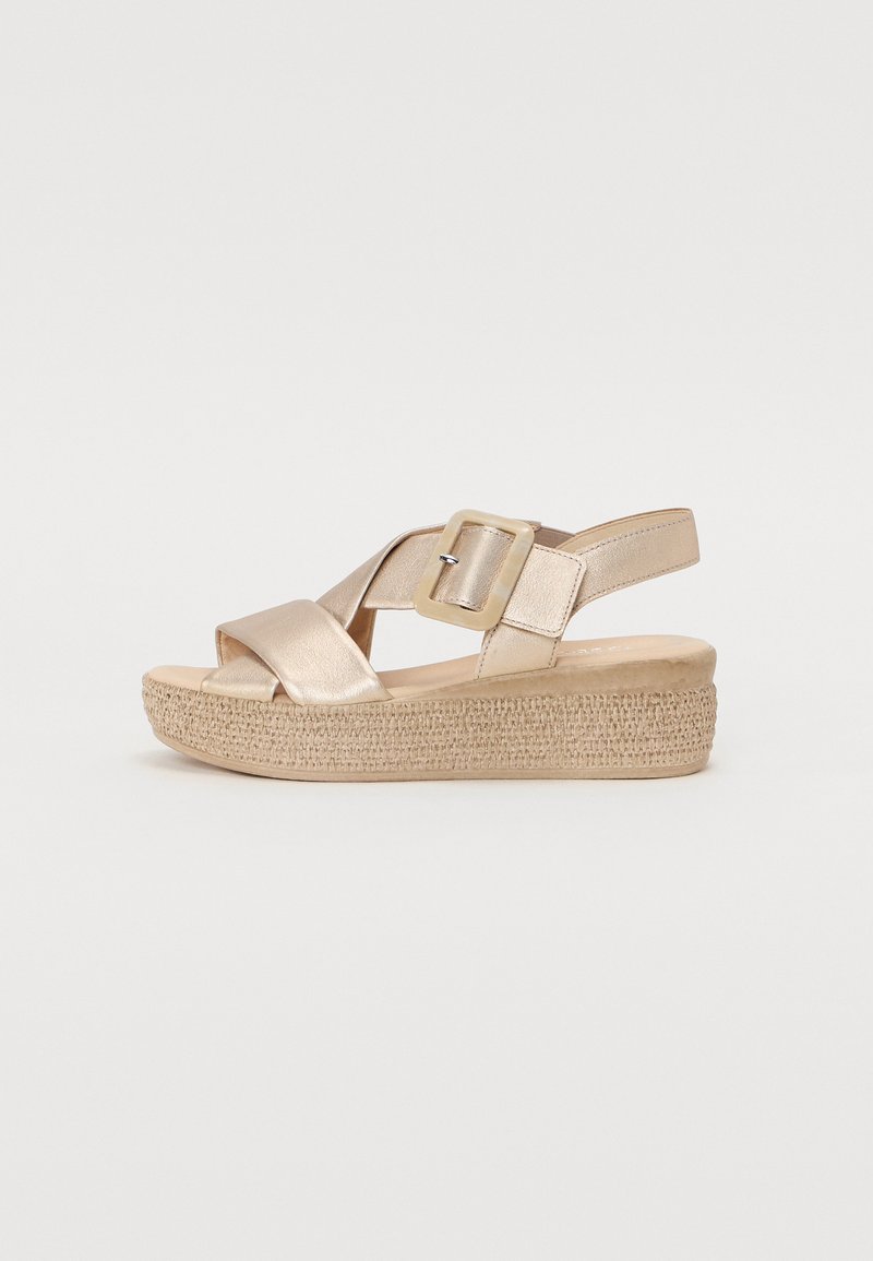 Metallic gold wedge sandals with cross-strap design, adjustable buckle, and woven texture on the platform for added grip.