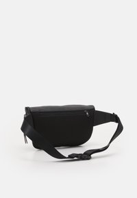 Schwarze Schultertasche mit glattem Oberteil, strukturiertem Netzfront, verstellbarem Tragegurt und Reißverschluss. Kompaktes und ergonomisches Design für eine einfache Handhabung.