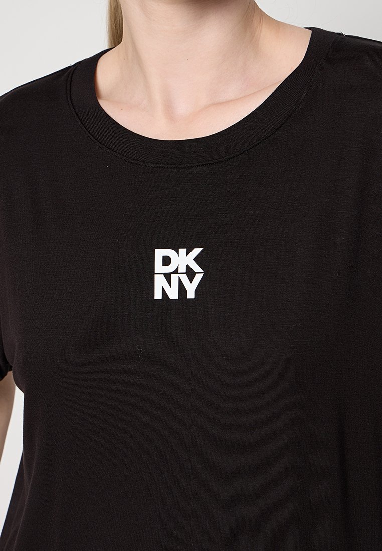 Czarna bawełniana koszulka z okrągłym dekoltem. Z przodu znajduje się białe logo DKNY. Miękka tekstura i luźny krój.