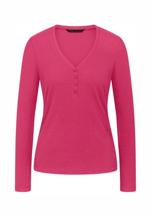 Długo rękawowa bluzka w kolorze jasnoróżowym z dekoltem w serek, wykonana z prążkowanej tkaniny, z pięcioma guzikami przy dekolcie. Gładka faktura i dopasowany krój.