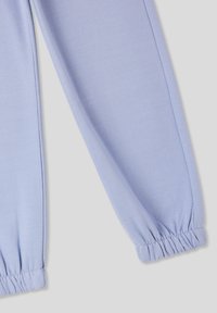 Pantaloni della tuta viola chiaro con polsini elastici. Tessuto morbido, design affusolato e cuciture sul lato. Nessun motivo visibile o accessori.