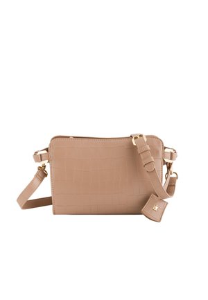 Beige Umhängetasche mit Krokodilprägung, verstellbarem Gurt und Beschlägen in Goldoptik. Rechteckige Form mit Reißverschluss und seitlichem Etikett.