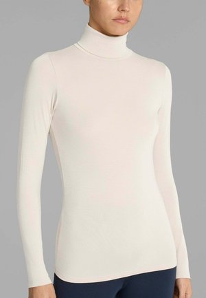 Maglia a maniche lunghe color beige chiaro con collo alto, realizzata in tessuto morbido e liscio, dalla forma aderente e con cuciture minime, caratterizzata da un collo a costine.