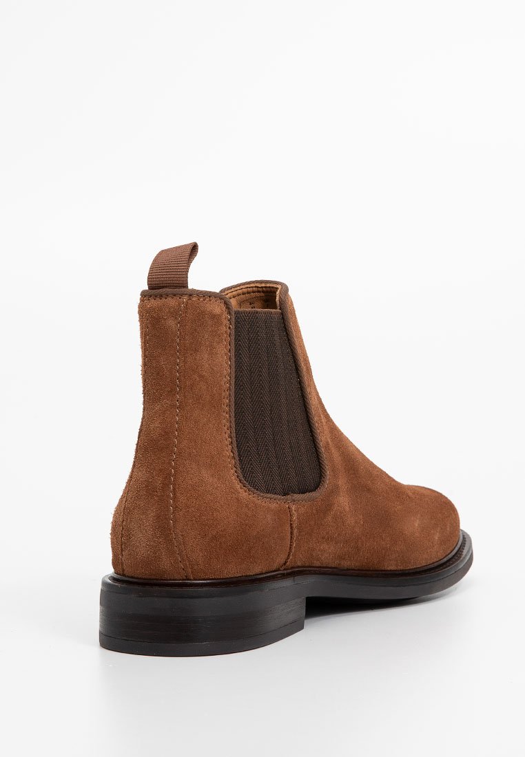 Brązowy zamszowy but Chelsea z elastycznymi panelami bocznymi i pętelką z tyłu, z drewnianym, grubym obcasem oraz gładkim, okrągłym noskiem.