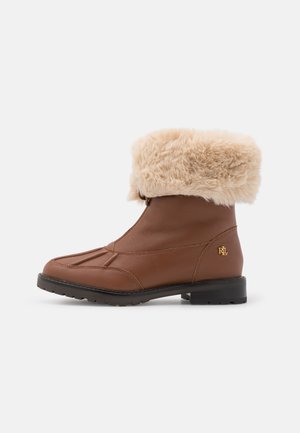 Bottine marron avec bordure épaisse en fausse fourrure beige, semelle noire, et petit logo doré "RL" sur le côté extérieur près du talon.