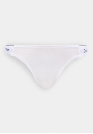 Perizoma a vita bassa da donna bianco con elastico con marchio Calvin Klein su sfondo neutro.