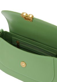 Grön läderhandväska med en rundad lock, guldiga detaljer och en magnetisk stängning. Inuti finns en ficka med dragkedja och mjukt foder.