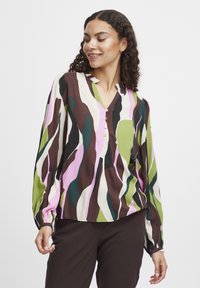 Farbenfrohe Bluse mit einem wellenförmigen Muster in Grün, Pink, Braun und Elfenbein. Hat einen V-Ausschnitt und drei dekorative Knöpfe vorne.
