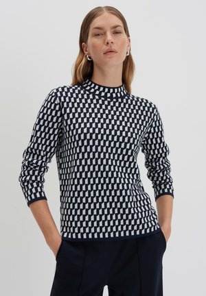 Strickpullover mit hohem Kragen, ausgestattet mit einem geometrischen Muster in Marineblau und Weiß. Lange Ärmel mit Rippbündchen, weiche Textur.