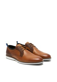Chaussures en cuir marron avec des accents en tissu marron texturé, bout rond, semelle en caoutchouc blanche et bleue, et détail de boucle de talon contrastant.