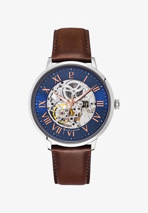 Mechanical watch with a blue dial, transparent case showing gears, rose gold accents, bronze hour markers, and a brown leather strap.