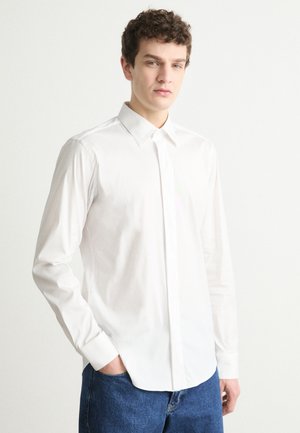 Nome della camicia: camicia bianca a maniche lunghe con colletto button-down, taglio slim e tessuto morbido. Il design include un orlo dritto e maniche con polsini.