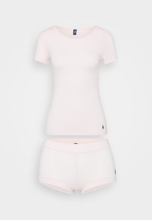 Chemise en coton rose clair à manches courtes avec un col rond, assortie à un short. Les deux articles présentent un petit logo.
