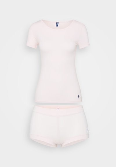 Ροζ βαμβακερό κοντομάνικο πουκάμισο με στρογγυλή λαιμόκοψη, συνδυασμένο με ταιριαστά σορτς. Και τα δύο αντικείμενα κοσμούνται από μία μικρή λεπτομέρεια λογοτύπου.