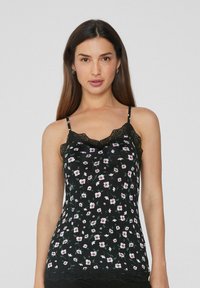 Camiseta sin mangas negra con flores y encaje, que presenta pequeñas flores blancas y rosas. Las finas tirantes y un diseño ajustado realzan la suavidad de la textura de la tela.