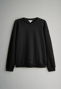 Felpa nera a maniche lunghe realizzata in misto cotone. Presenta un collo a giro, polsini a costine e una vestibilità rilassata. Texture morbida, design minimal.