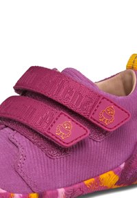 Scarpa in tessuto viola con strap in velcro, caratterizzata da una superficie testurizzata e da una suola multicolore con motivo. Include un piccolo dettaglio con logo a forma di gufo.