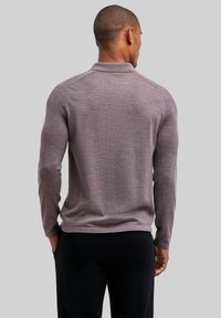 Koszulka polo z długim rękawem z miękkiej, jasnoszarej dzianiny, z klasycznym kołnierzykiem, dopasowanym krojem i minimalistycznym designem. Bez widocznych wzorów.