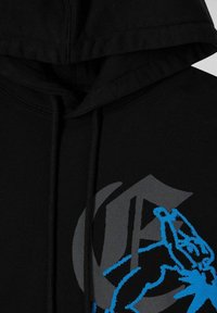 Felpa nera con cappuccio decorata da un design grafico blu di una figura su uno sfondo grigio, dotata di cordini e un tessuto testurizzato.