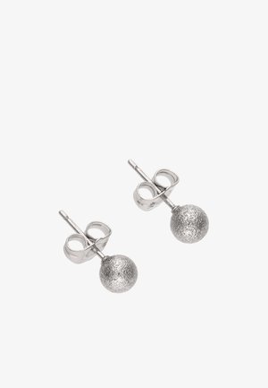 Par af teksturerede, sølvfarvede ørestikker med låse bagpå på hvid baggrund.