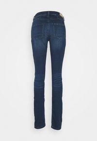 Mörkblå denimjeans med slim fit, med en medelhög midja, fem fickor och en ren baksida med subtila blekningar på låren.