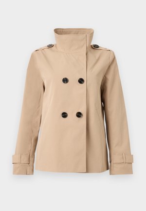 Veste beige croisée avec col montant, boutons noirs, épaulettes et brides réglables aux poignets sur les manches longues.