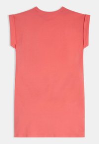 Koralowa sukienka t-shirt z krótkimi podwiniętymi rękawami, okrągłym dekoltem oraz gładką, miękką fakturą. Prosty design bez wzorów i ozdób.