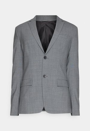 Grå blazer laget av strukturert stoff, med utskåret revers, to-knapp lukking og to frontlommer. Innvendig fôret i svart.