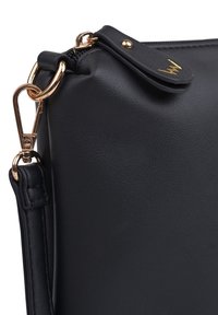 Černá kožená kabelka s hladkým povrchem, vybavená zlatými kovovými detaily, stahovacím poutkem a odnímatelným popruhem pro všestranné možnosti nošení.