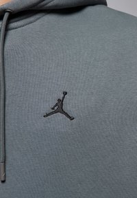 Felpa con cappuccio in morbido tessuto grigio chiaro, caratterizzata da un logo Jumpman ricamato in nero sul petto. Cordini regolabili sul cappuccio.