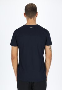 Maglietta a maniche corte di colore blu navy con collo rotondo, texture liscia e un piccolo logo sul retro nella parte superiore. Design semplice, senza motivi.