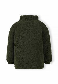 Veste en polaire verte olive avec un extérieur texturé et duveteux, col haut, manches longues et poignets noirs. Pas de fermetures ni de poches visibles.