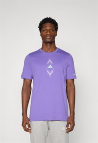 Lilla kortærmet t-shirt i bomuldsblanding med geometrisk grafik i lys blå, har en rund halsudskæring og løs pasform.