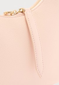 Ροζ δερμάτινη τσάντα με υφή, με χρυστό φερμουάρ και τράβηγμα, ραμμένα άκρα και στρογγυλεμένο πάνω μέρος.