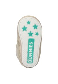 Suela de zapato con purpurina dorada y banda de goma blanca, que presenta una estrella turquesa y la marca "BUNNIES". Tamaño 18 indicado en la suela.